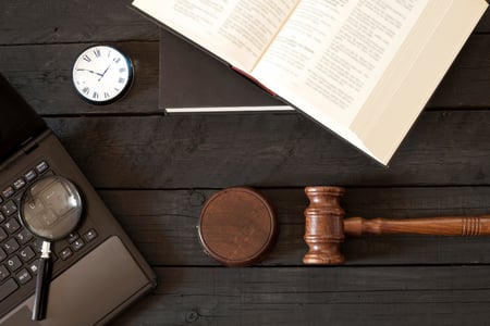 a gavel sits beside a law book and computer