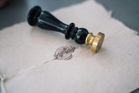 a wax letter seal sits above a written letter