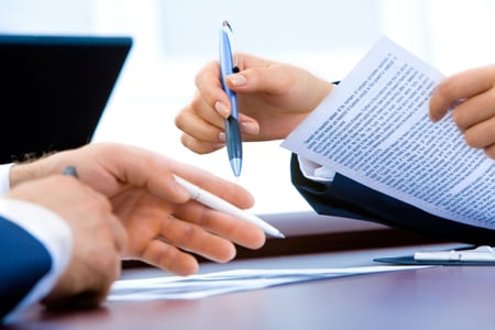 two people look over and mark up a legal document