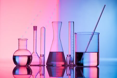 pink and purple background with beakers