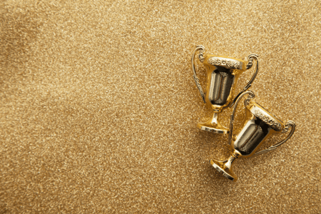 gold glitter background with two gold trophies